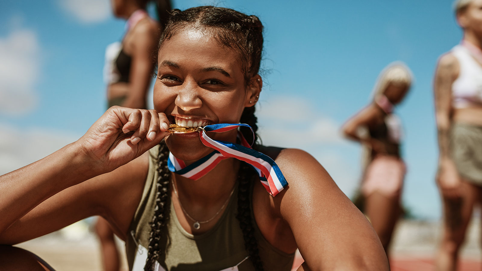 athlete biting on medal